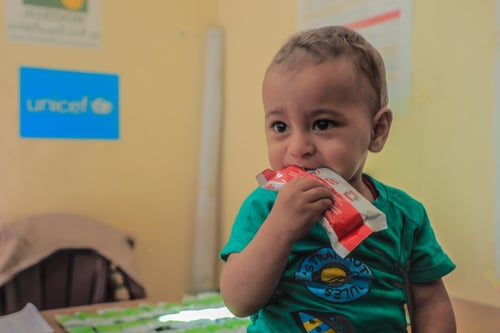 A young Gazan boy eats from a sachet of ready-to-use therapeutic food in a UNICEF-supported health clinic. 