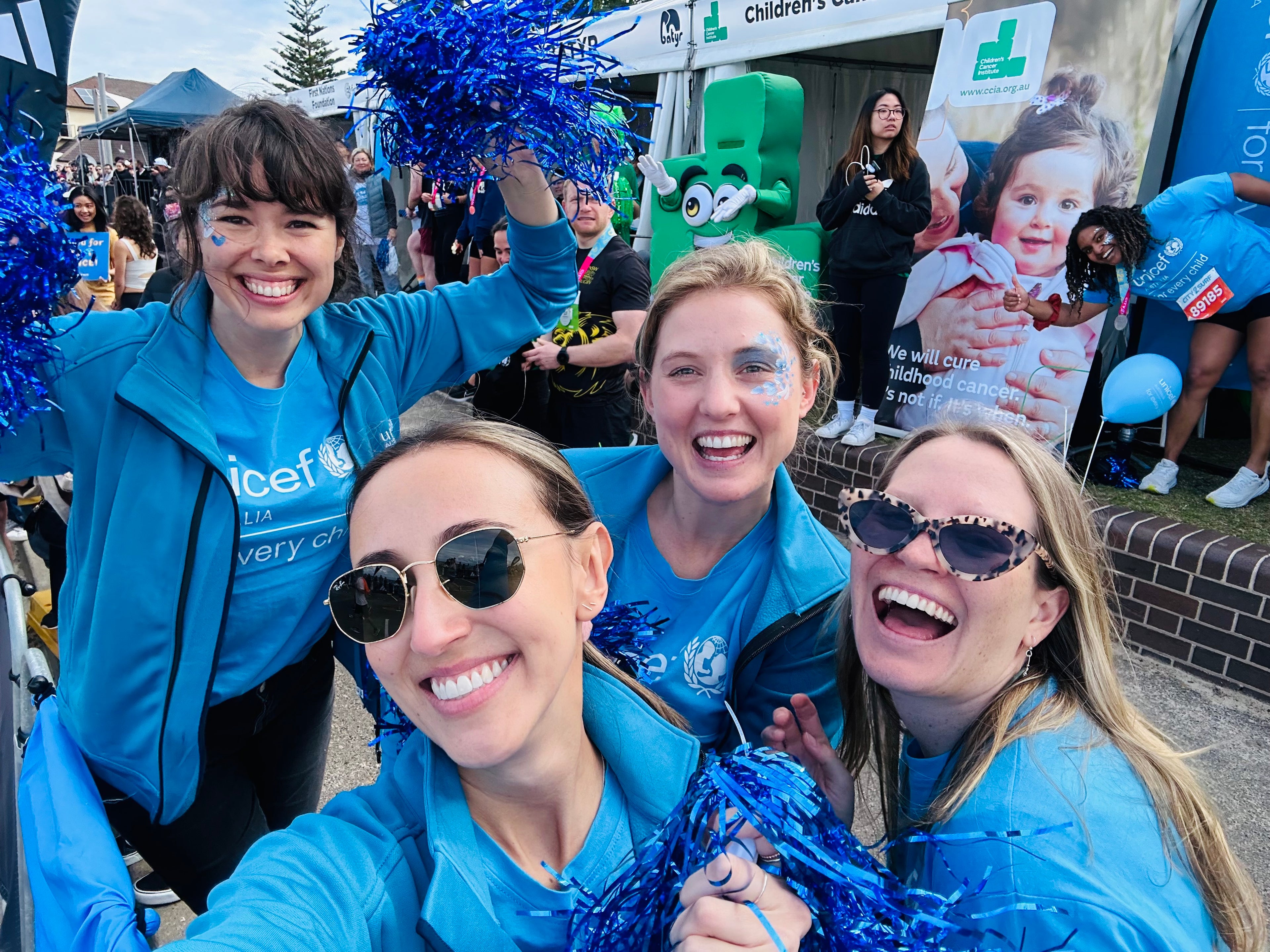 A group of four women wearing UNICEF T-shirts smile in a selfie.