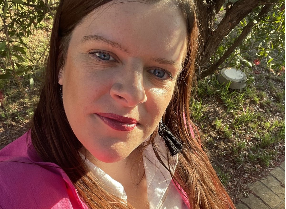 A selfie of a woman with blue eyes and long brown hair.