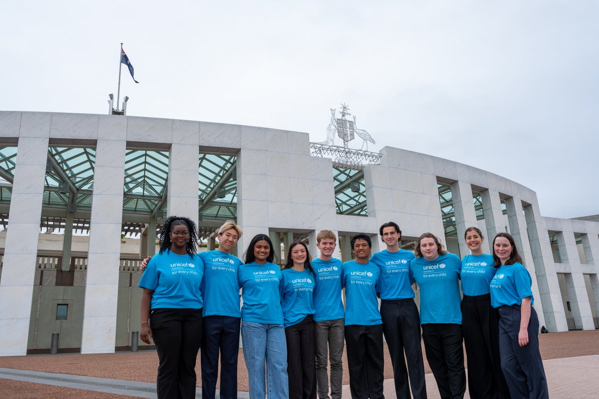 A group of young people standing outside of Parliament House. 