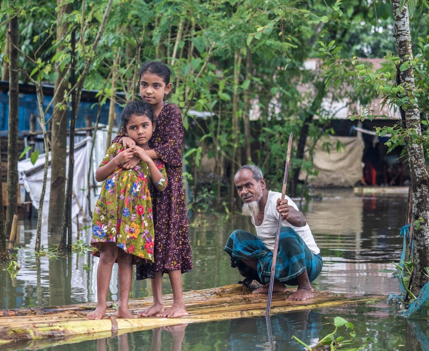 A man rowing children to safety during floods