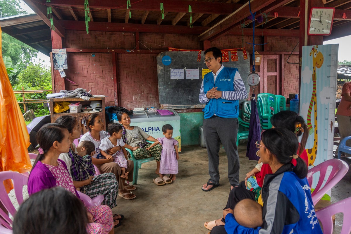Mothers and their children living in a displacement site participate in a nutrition awareness session organised by UNICEF Myanmar. 