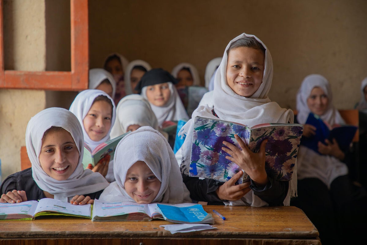 A young girl stands and reads in front of her class 
