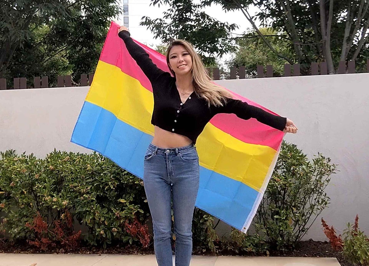 Emily smiles at camera holding flag