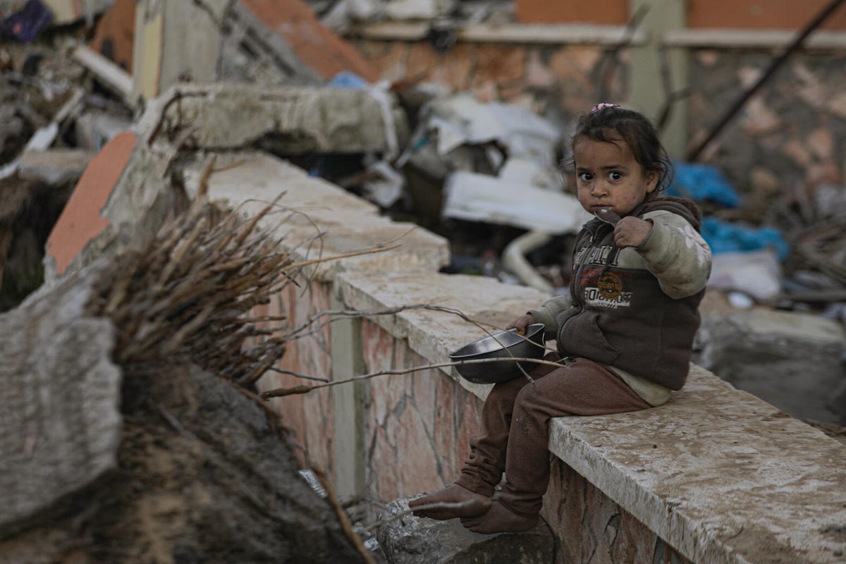 Two-year-old Alma eats the little food that’s available among the rubble.