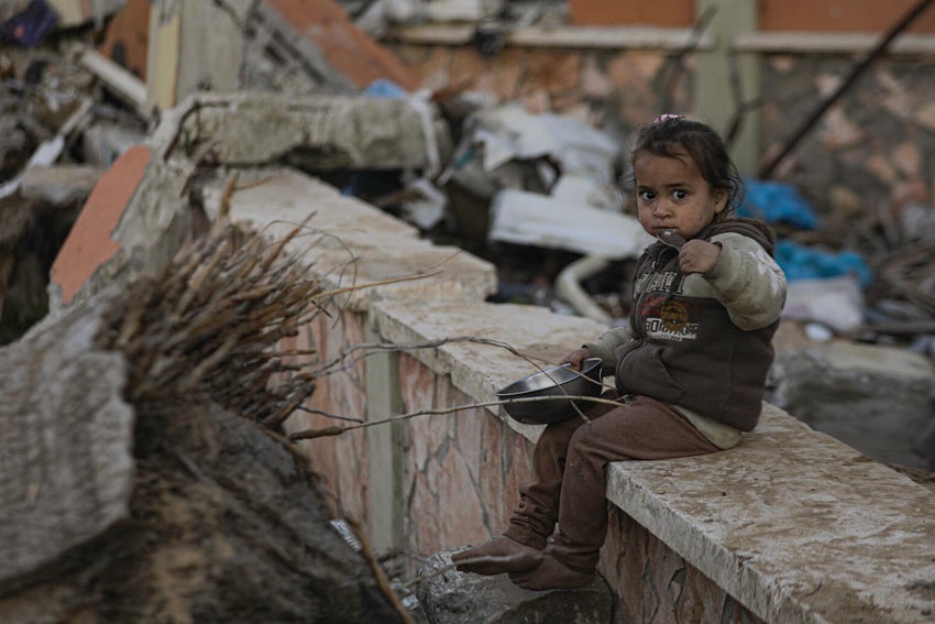 Two-year-old Alma eats the little food that’s available among the rubble.