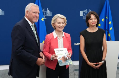 European Commission President Ursula von der Leyen poses with a man and women on either side.