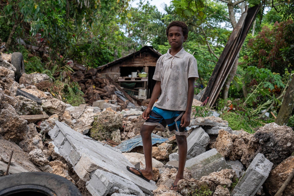 An 11-year-old boy stands amongst the ruins of his home that was destroyed by a landslide following the earthquake to hit Vanuatu on 17 December 2024.