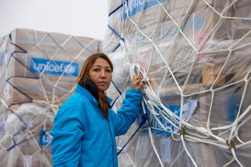 A UNICEF worker stands in front of a shipment of supplies from the UNICEF warehouse in Denmark.