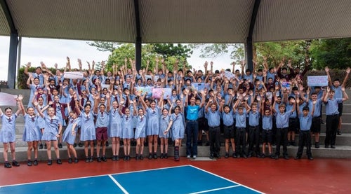 School children cheering in playground.
