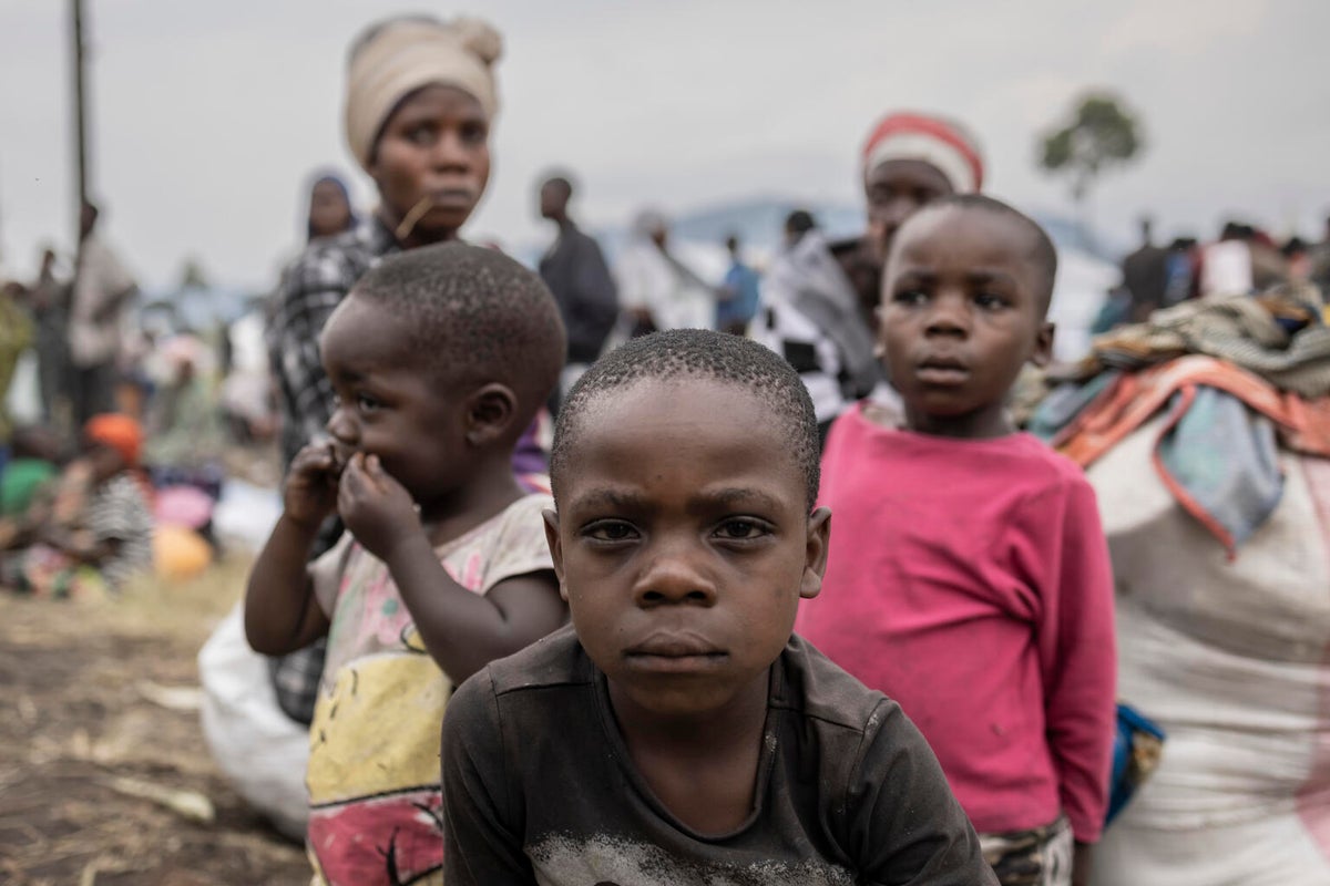 At a camp for internally displaced people, a mother sits with her three children after walking for three days to escape the violence in her home village.  