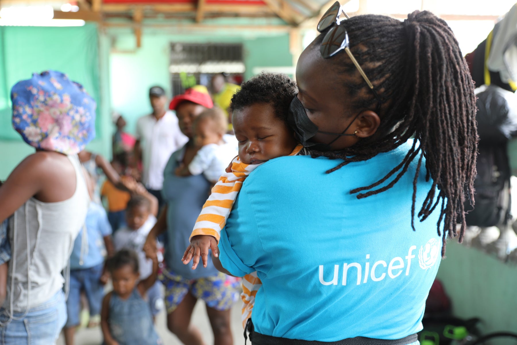 UNICEF staff member holding a child