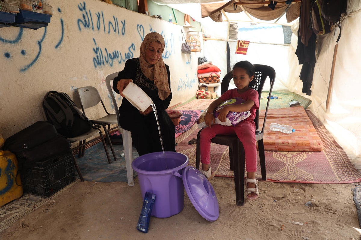 Wisam and her seven-year-old niece sit in front of her tent in the Gaza Strip.  