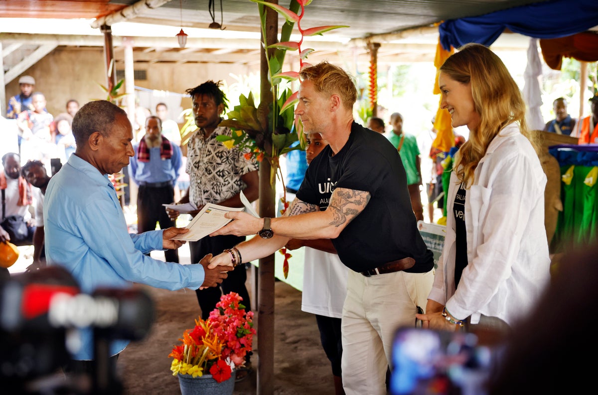 Ronan and Storm hand over a certificate to one of the caregivers who has completed the P4CD program.