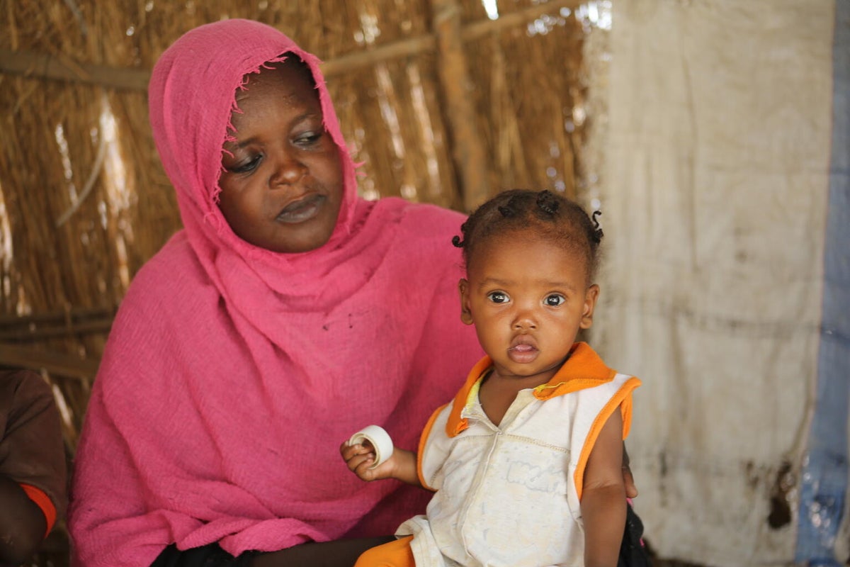 An aunty watches over her seven-month-old niece, who is recovering from malnutrition in a UNICEF-supported nutrition program.