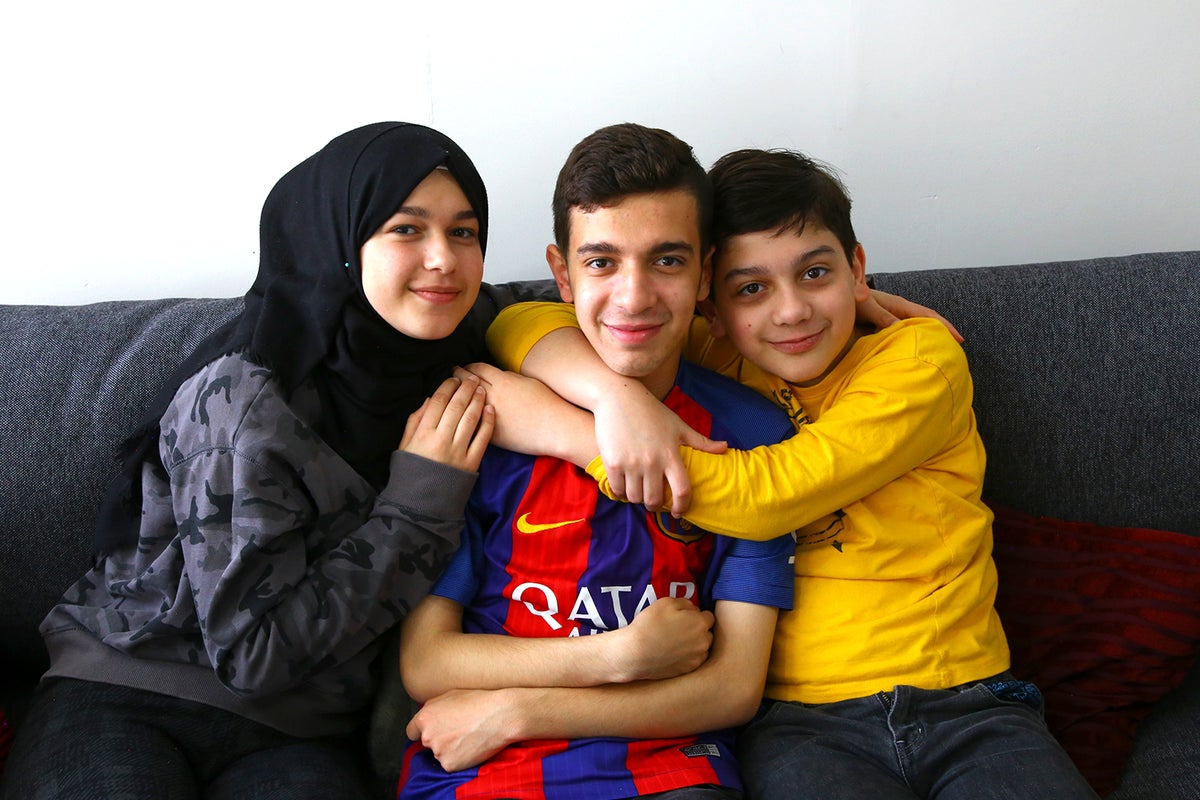 Three siblings sitting on lounge
