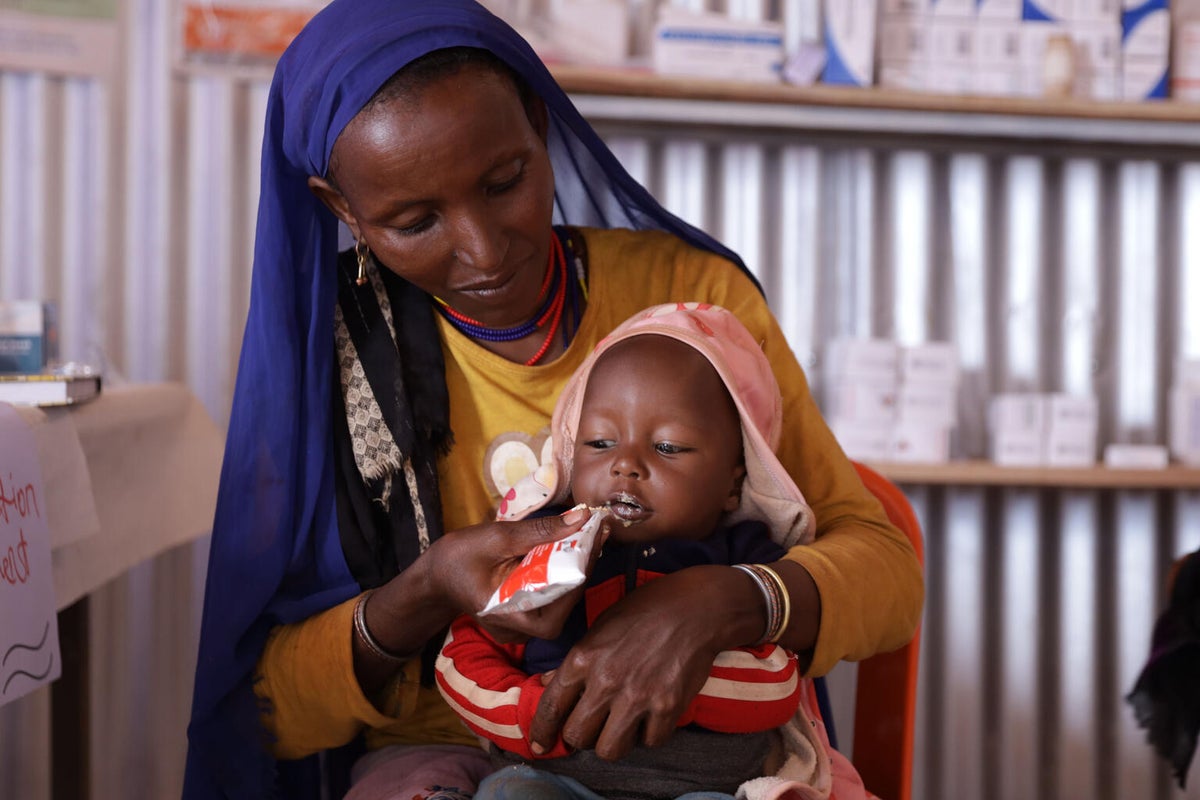 Diyo, a mother of three, feeds ready-to-use therapeutic food (RUTF) to her nine-month-old baby as they recover from severe malnutrition in Ethiopia