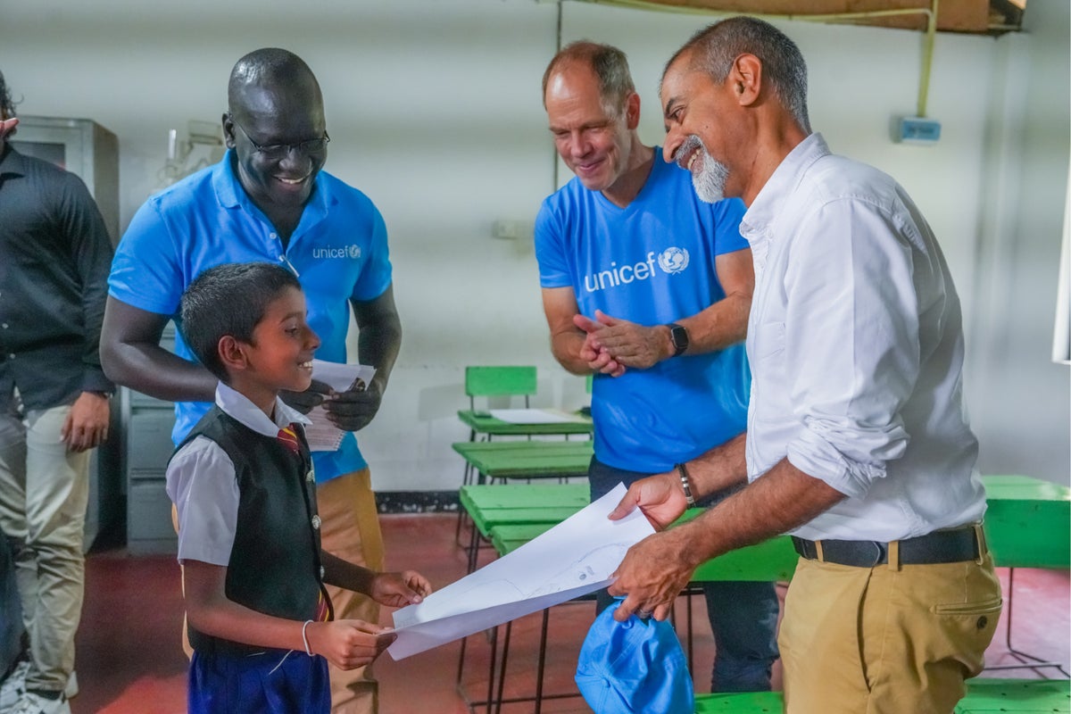 Bismarck Swangin and other UNICEF Sri Lanka staff interact with a young boy during a visit to a school in Sri Lanka. 