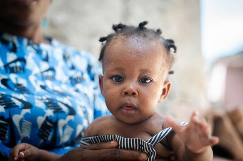 A young girl holds her mum's hand