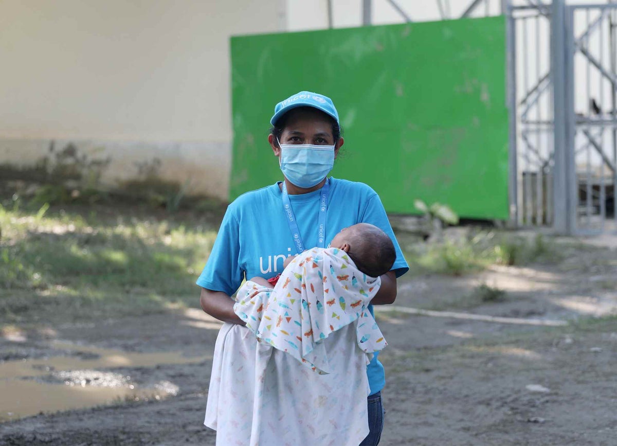 UNICEF Timor-Leste Child Protection Officer, holds a baby of a family who has been displaced by the flooding. 