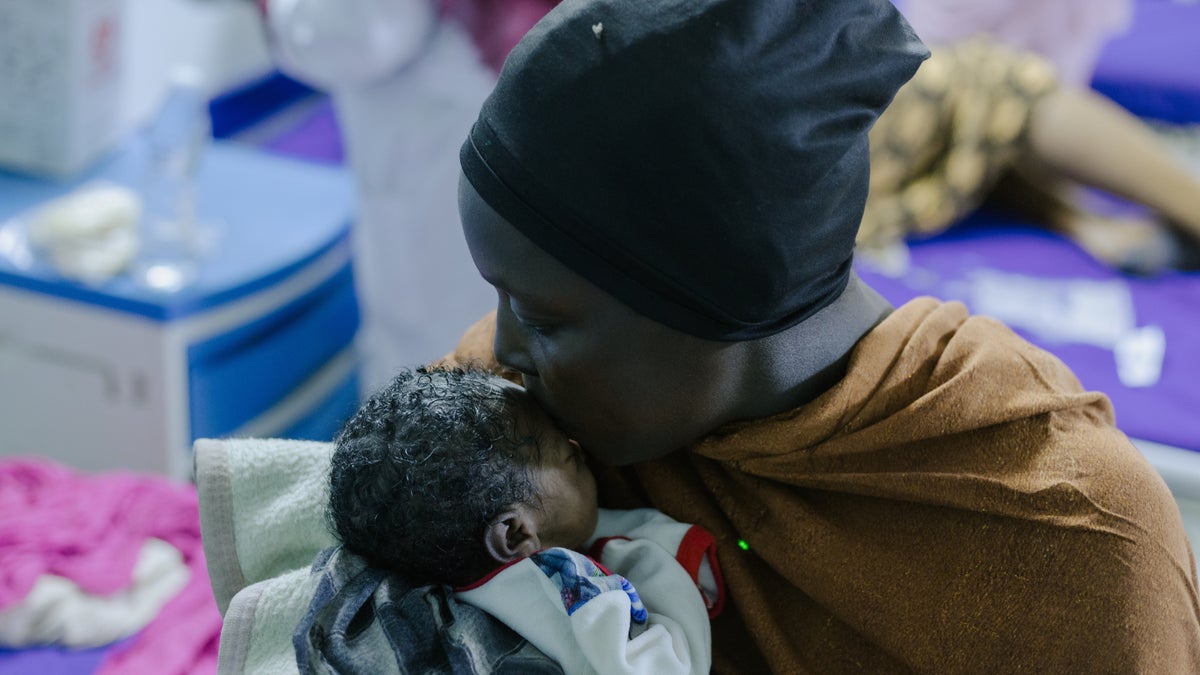 A mother cuddles her baby after delivery at a hospital in Sudan.