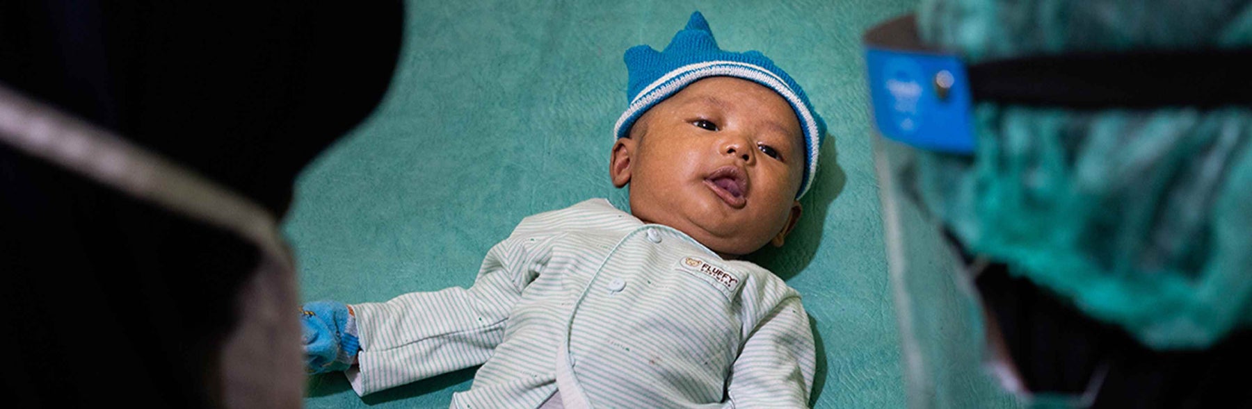 baby laying on bed receiving covid-19 treatment