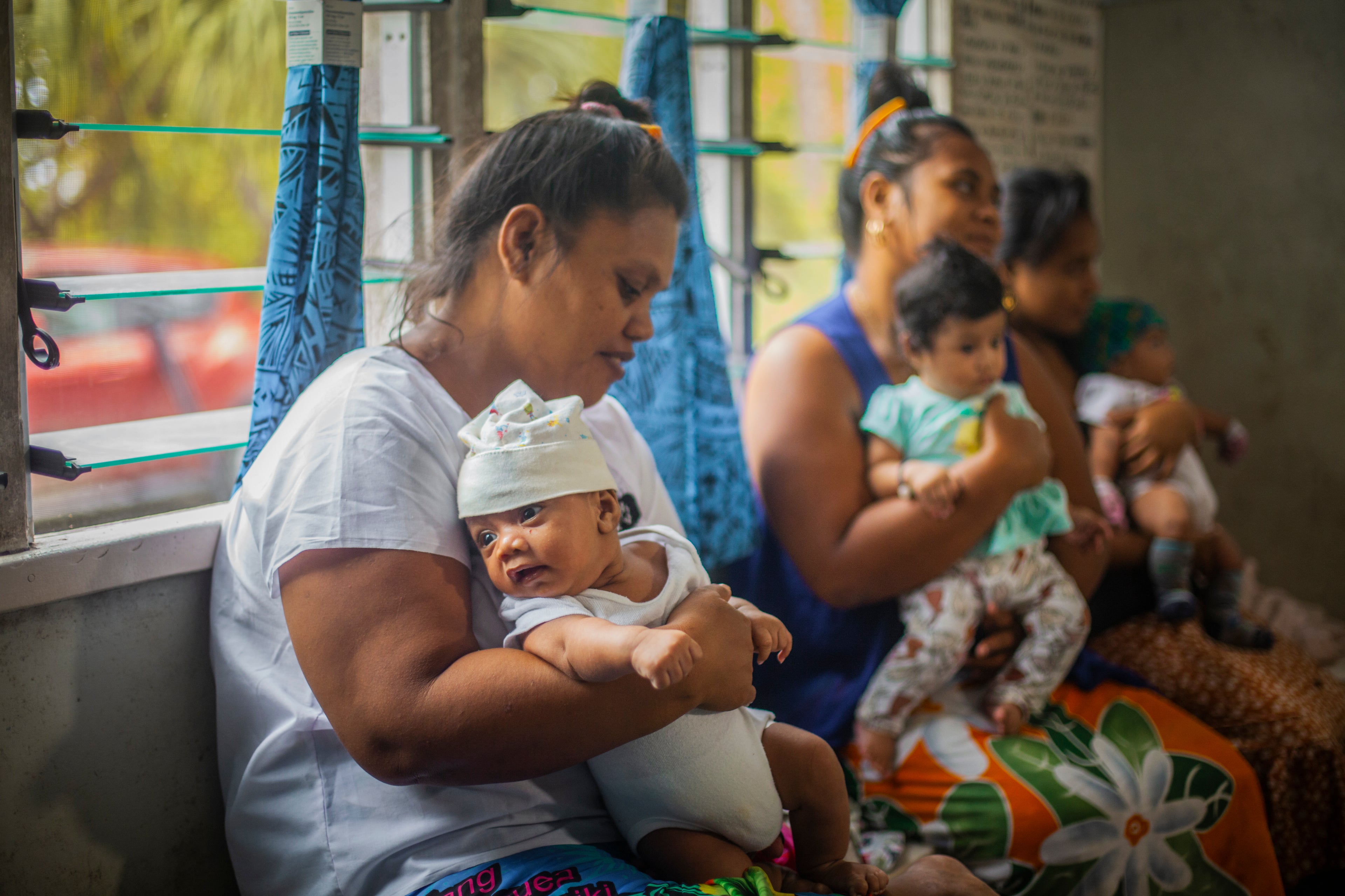 mothers and babies in a waiting room in a health clinic