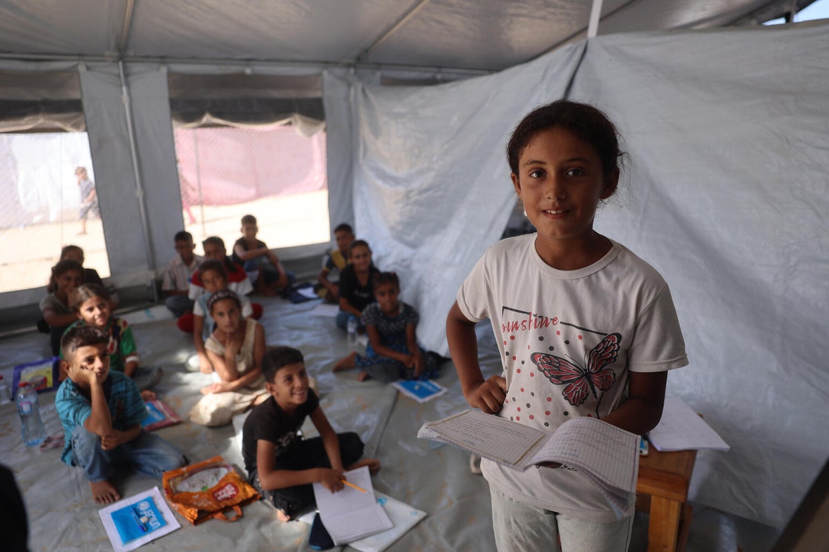 A young girl reading in a temporary classroom in Gaza