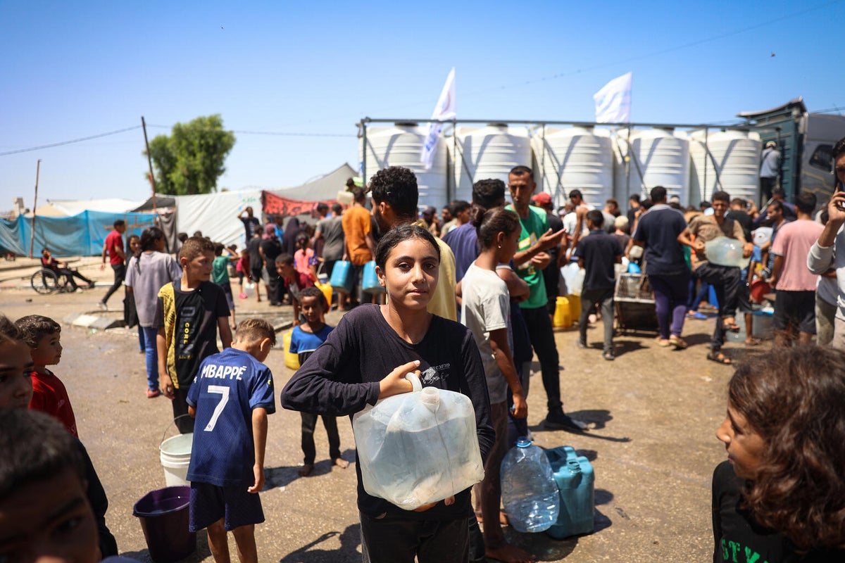 A young girl collects water from a UNICEF-supported water truck