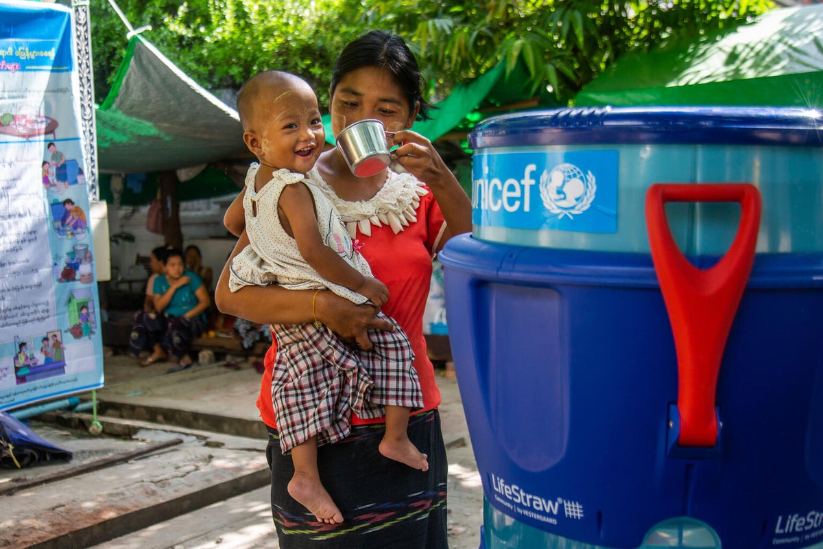 Ma Aye Su Mon, 30, and her daughter drink safe water from a purifier supported by UNICEF at a camp in Myanmar. The purifier helps to prevent diarrhoea and other waterborne diseases. 