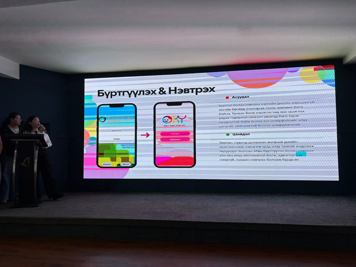 A girl presenting her team’s ideas on a large screen at the Oky Hackathon.