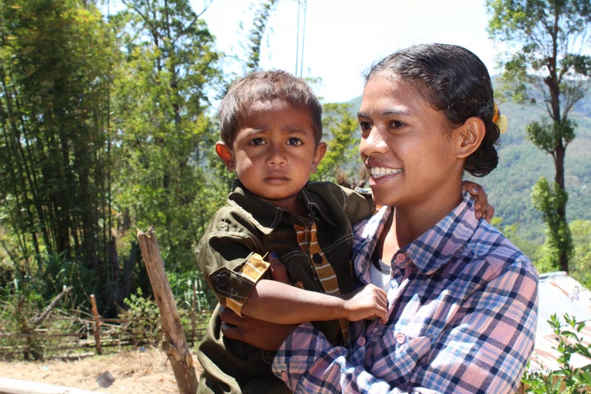 A young mother holds her child at a UNICEF-supported Girls Empowered program.