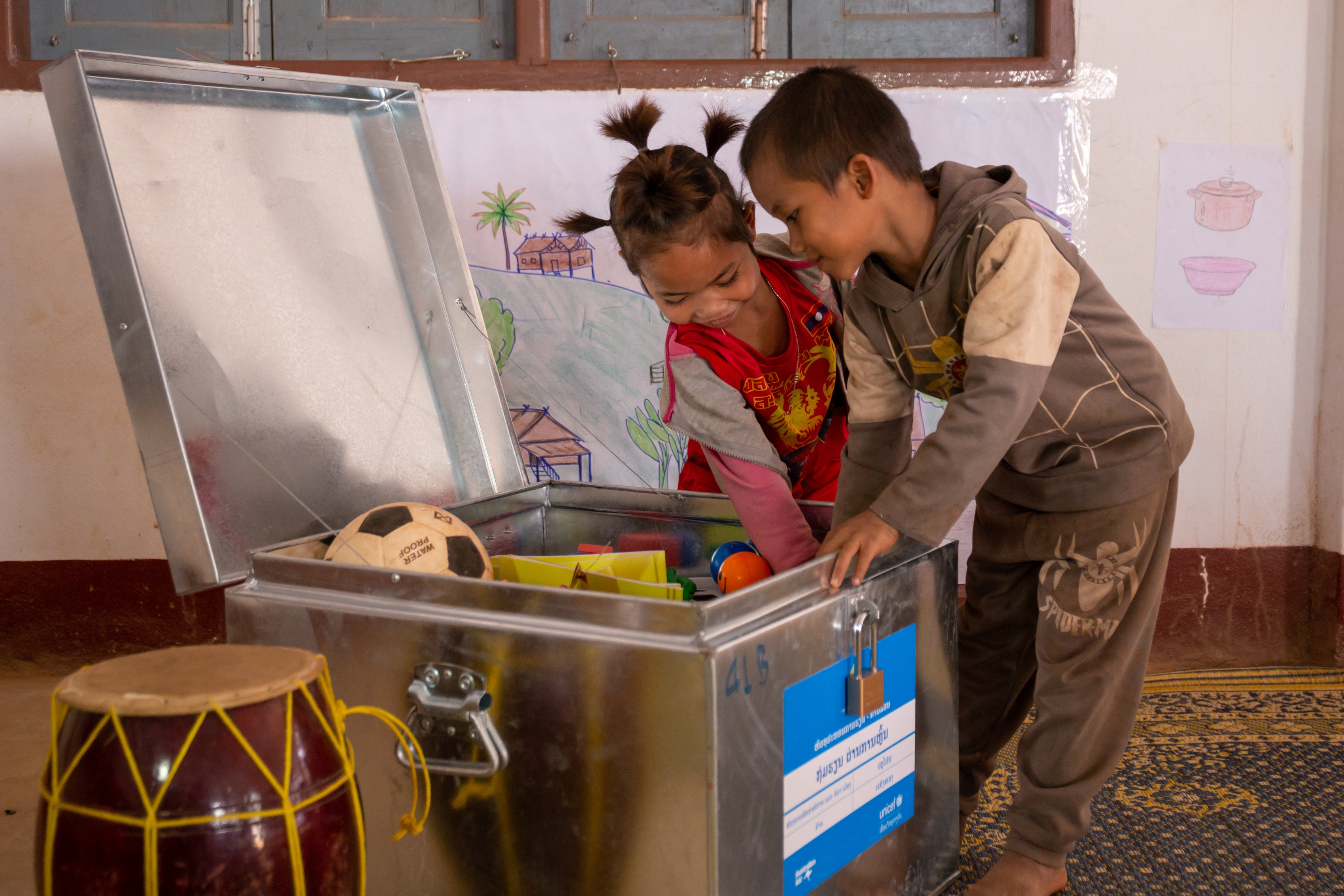 Ki and Keosy play excitedly with the education toolkit, provided by UNICEF Australia