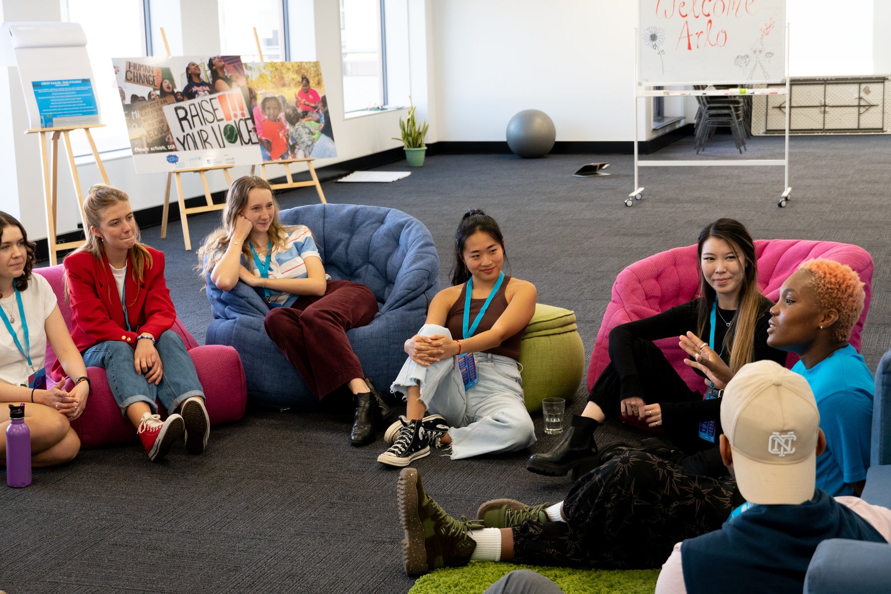 A group of young people sitting on beanbags watch on as UK UNICEF Ambassador Arlo Park speaks.