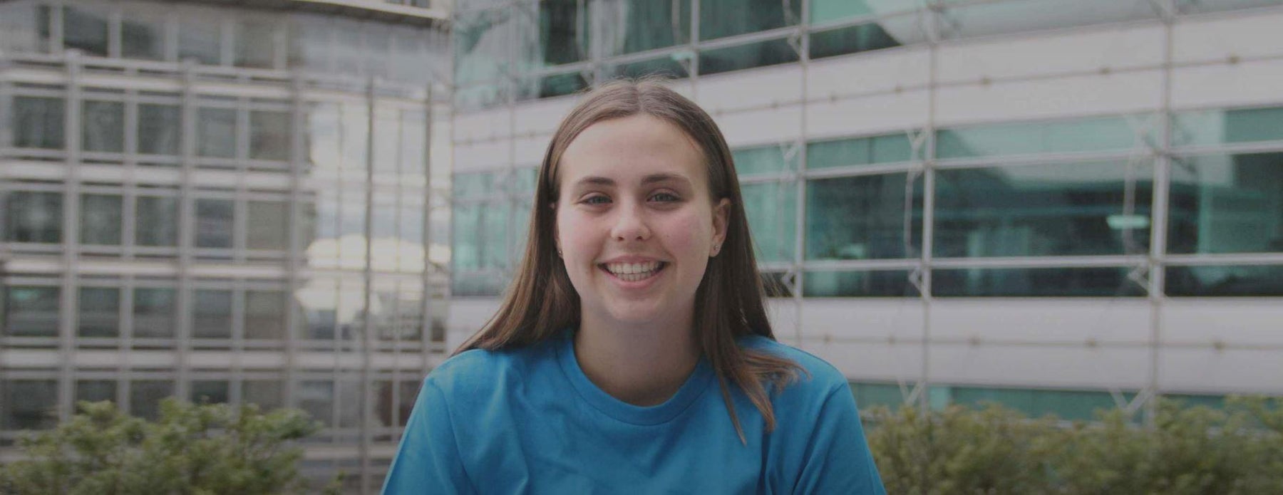 A young woman smiling to the camera. She is wearing a UNICEF t-shirt
