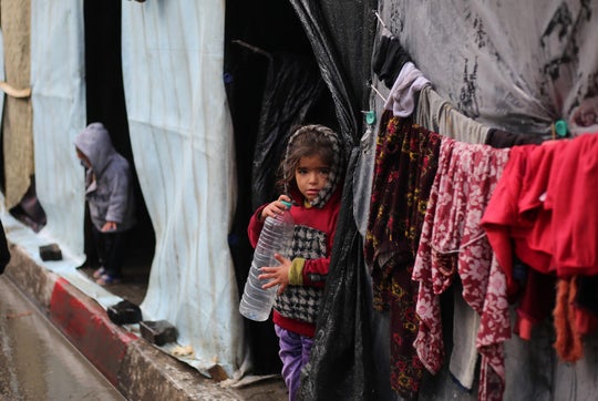 Young girl in Gaza standing out the front of her temporary home.