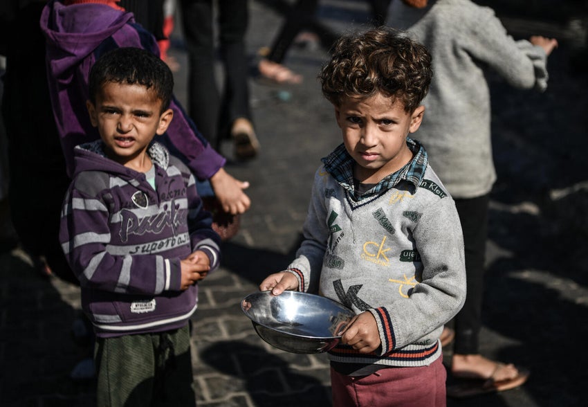 Two children wait for food at an aid distribution site in Gaza.