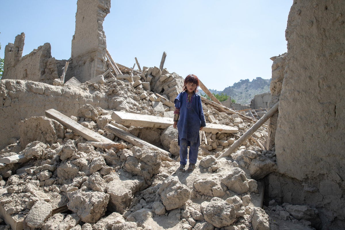 A boy is standing on a pile of rubble