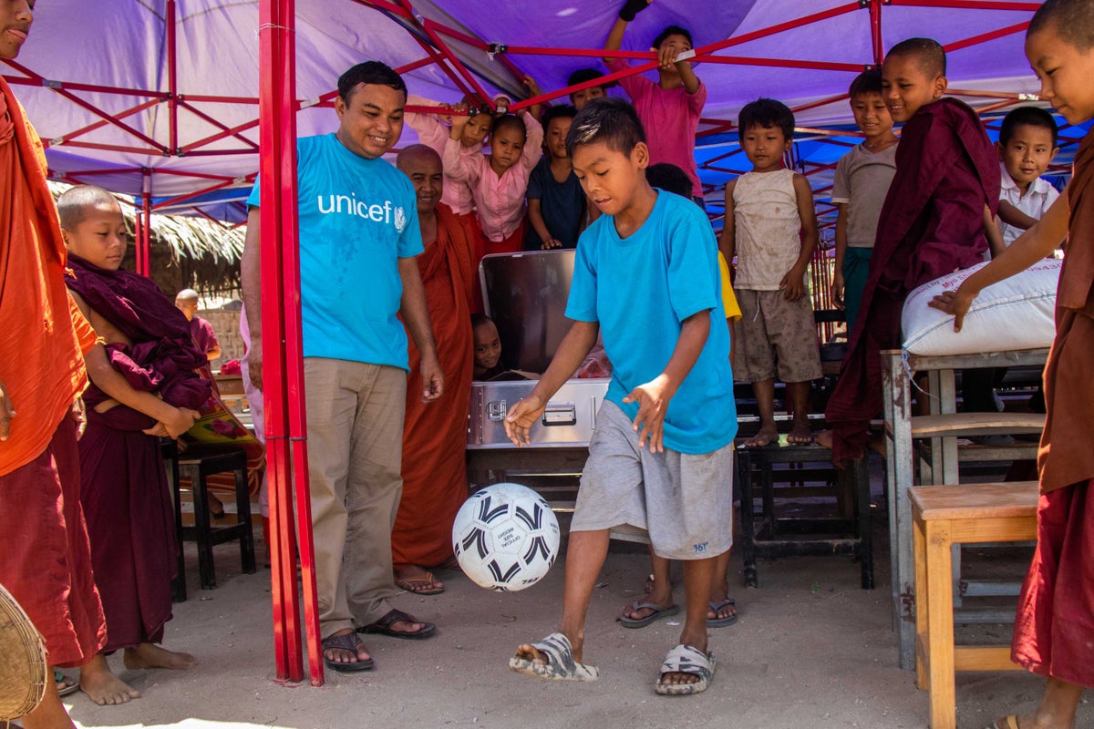 Displaced children play with a ball after receiving a recreation kit from UNICEF.