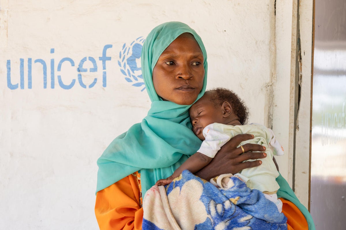 Qabil carries her child Mohammed during a follow-up visit at a UNICEF-supported health clinic.