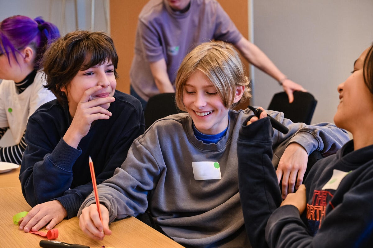 Three smiling boys in a classroom