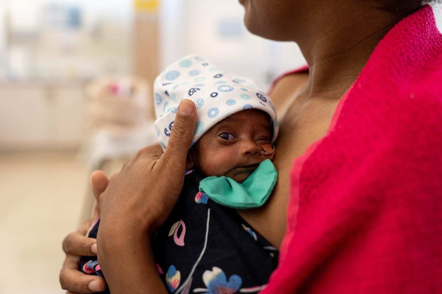 A newborn being held by their mother. 