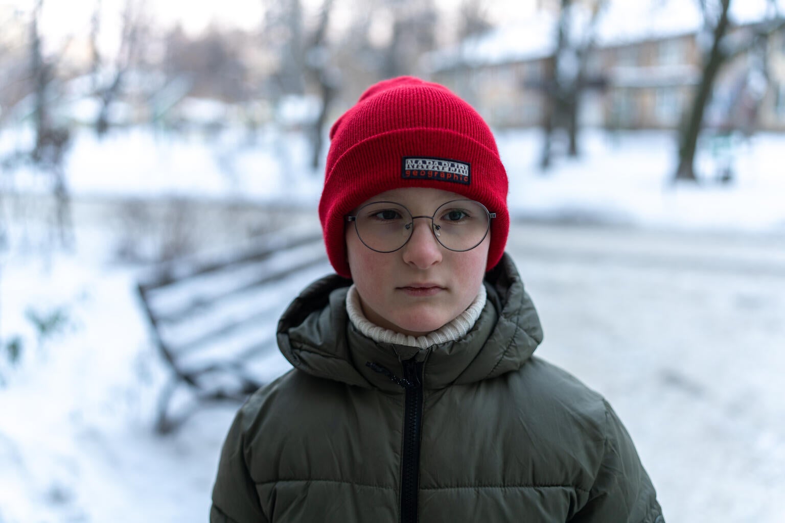 Eight-year-old Yehor stands outside his home, after returning with his mother from a shopping centre where they went to charge phones and warm up during power outages.