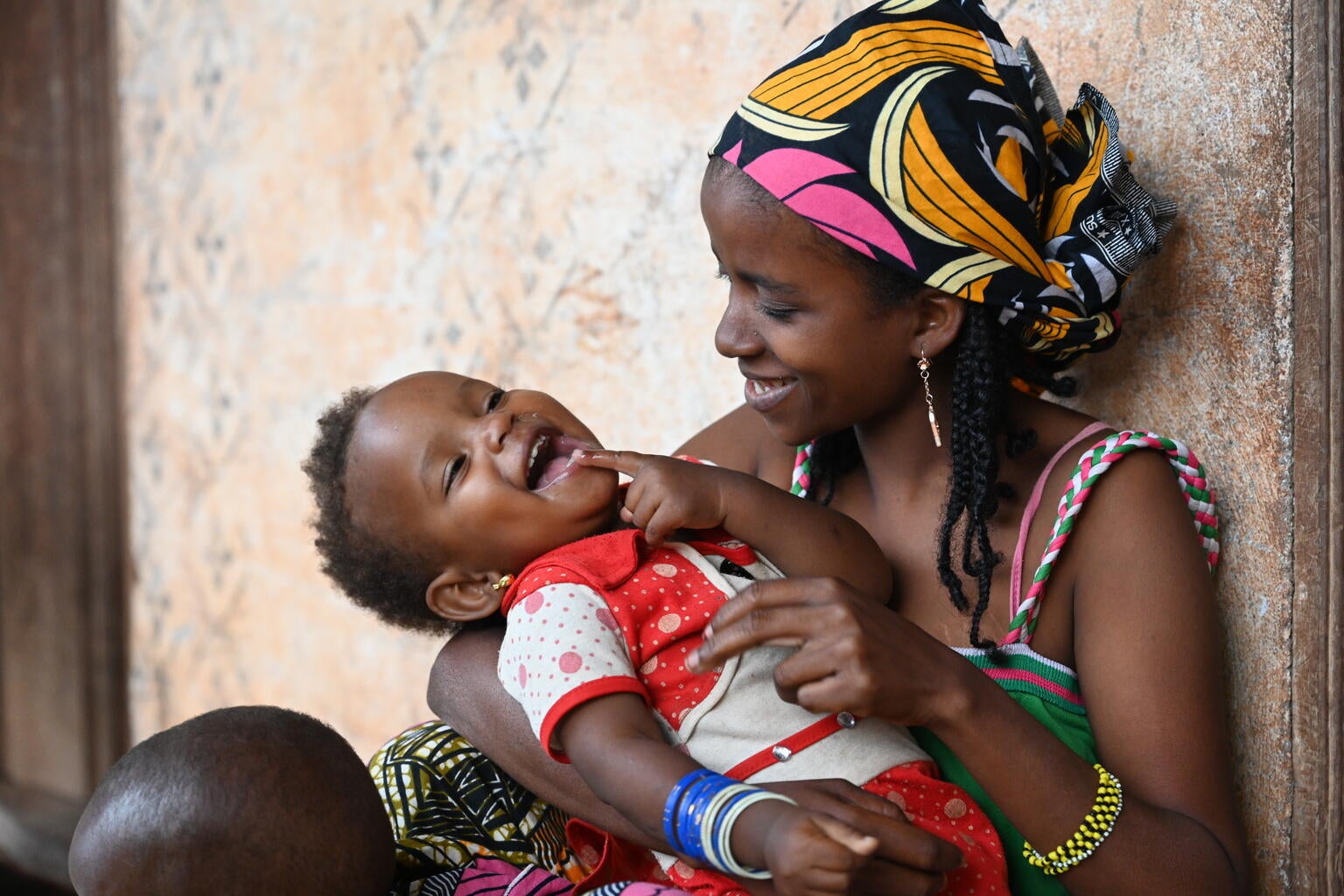 Mother and son from Cameroon hugging and smiling.
