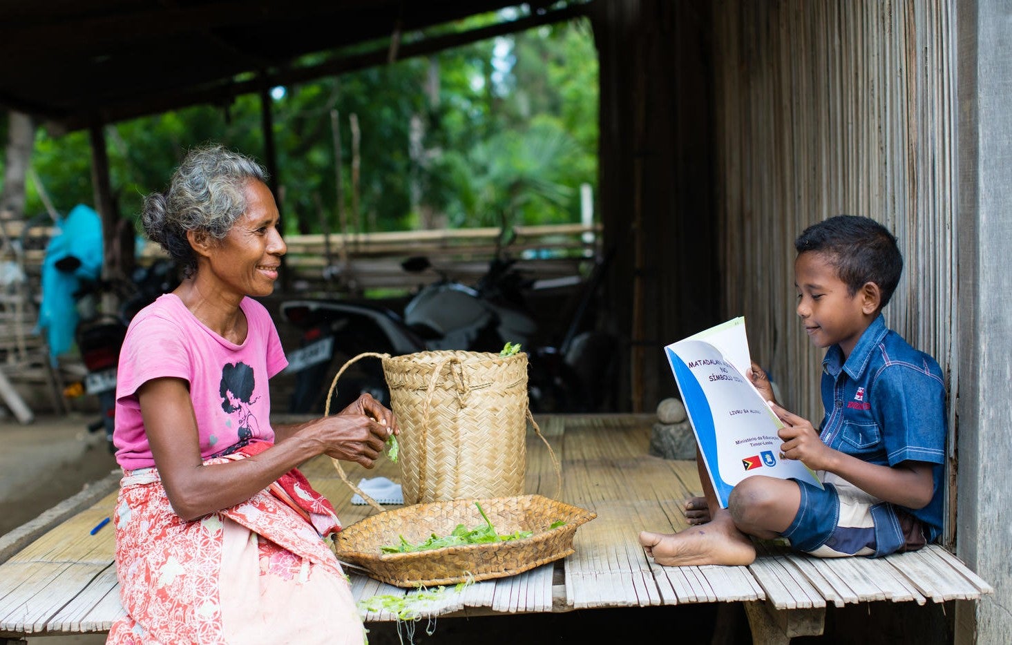 Young boy reading to his grandmother