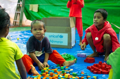Young children sit amongst coloured blocks