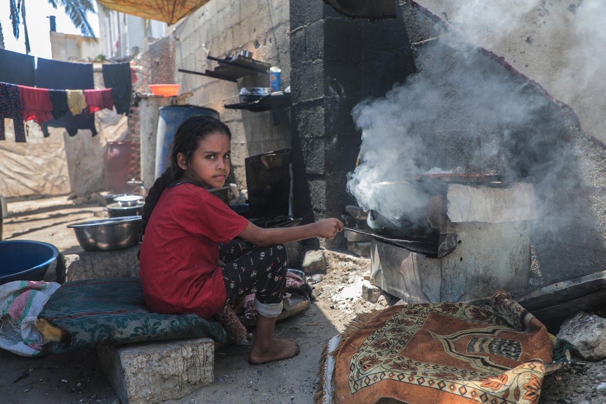 Eleven-year-old Rafif cooking outside their temporary shelter in Gaza. 