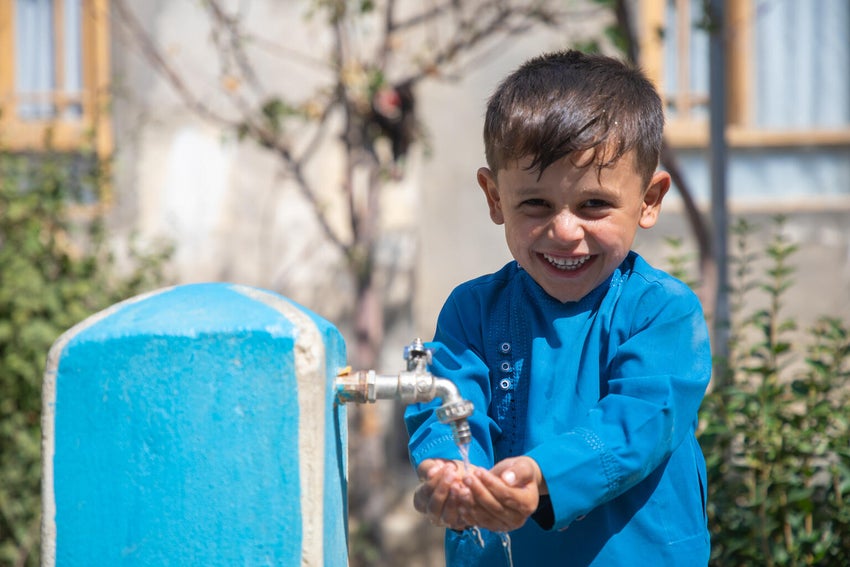 In Afghanistan, six-year-old Menallah washes his hands from a new water tap installed outside his home. 