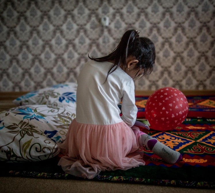 Young girl sitting on the floor with head bowed