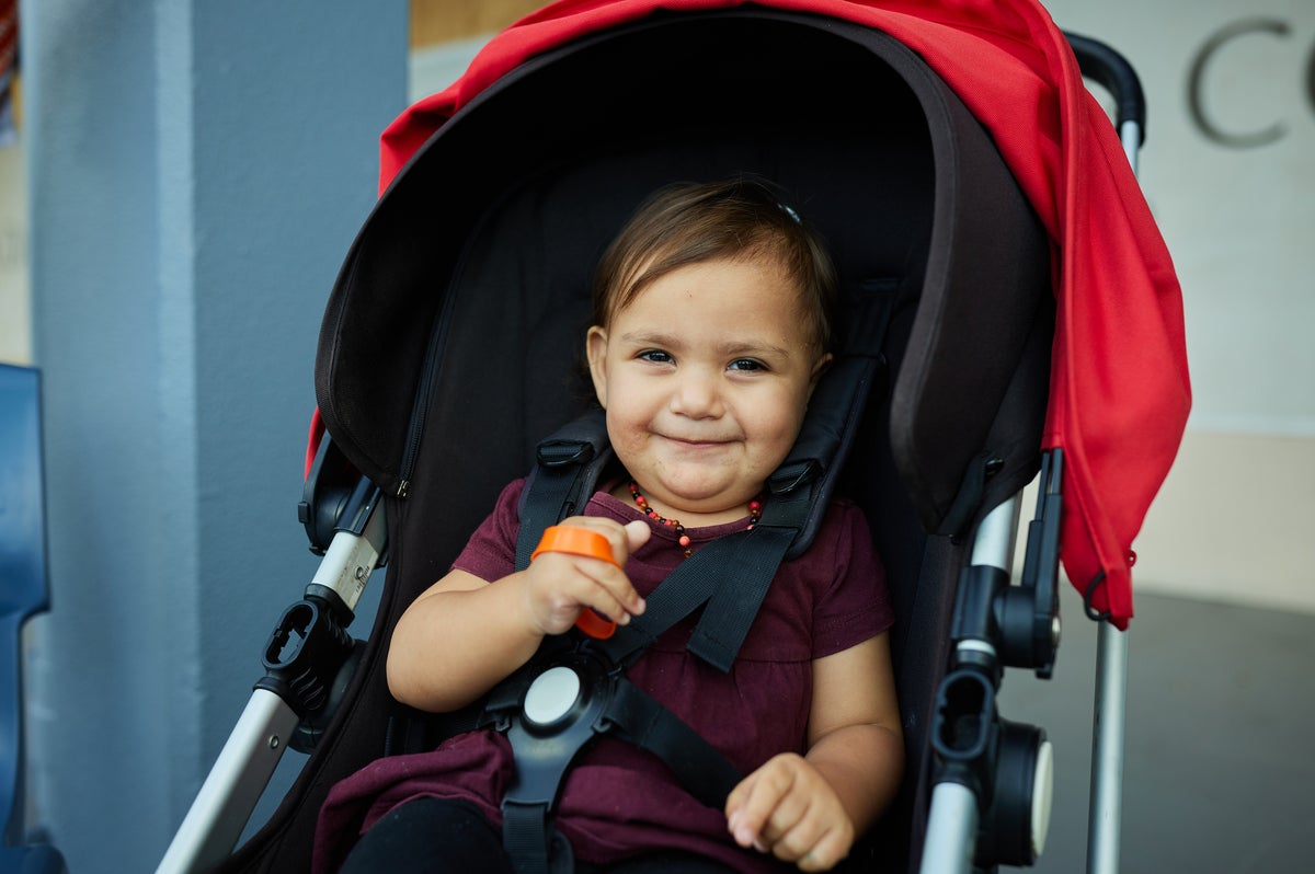 A young smiling child in a pram. 